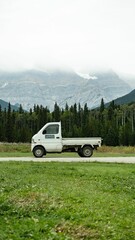 White pickup truck with mountain backdrop. © Wirestock