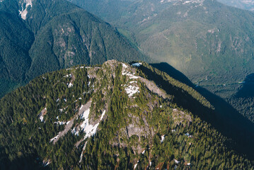 Green mountain peak with traces of snow on the top