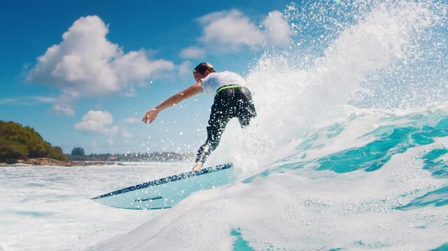 Teen boy surfer rides the wave and makes sharp turn with spray. Tropical surfing in the Maldives