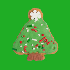 Homemade gingerbread colored cookie „Decorated Christmas tree“ on green, isolated Christmas handmade gingerbread cookie „Decorated Christmas tree“ on green background, top view, flat  lay