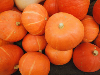 Display of a crop pumpkins on top market display ready for the fall season, halloween. Orange autumn pumpkin.