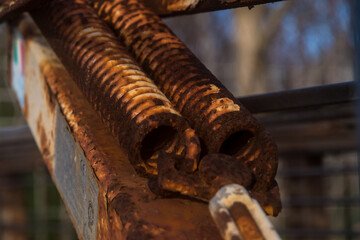 Dettaglio di due molle metalliche arrugginite di un macchinario industriale illuminate dalla luce del tramonto