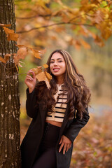 portrait of a beautiful woman with long hair posing in an autumn landscape in a forest