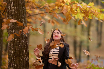 portrait of a beautiful woman with long hair posing in an autumn landscape in a forest