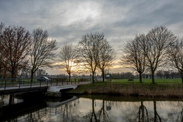 Bridge and sunset reflection over calm river