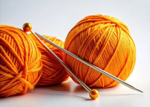 Bright orange yarn and knitting needles showcased on a white backdrop, essential crafting tools for every knitter. Ideal for creating lovely, warm projects and inspiring creativity.