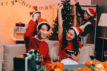 Group of young Asian man and women as friends having fun at a New Year's celebration, holding gift...