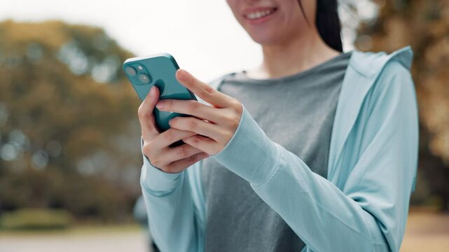Hands, sports and woman with phone in park searching for online exercise program for health. Fitness, cellphone and female athlete typing on browsing website for workout routine outdoor in Japan.