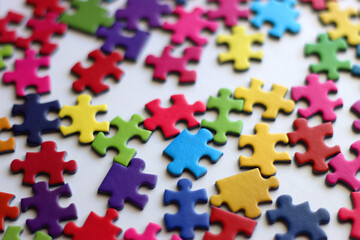 Colorful jigsaw puzzle pieces on white background. Selective focus.