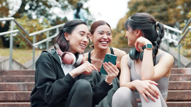 Fitness, phone and steps with athlete friends outdoor together for cardio, training or workout. Break, exercise and smile of Japanese women on stairs for communication, tracking or update with app