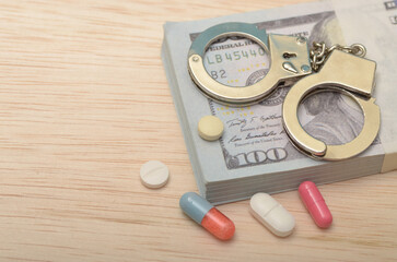 Crime and Justice Concept: Banknotes, Handcuffs, and Drugs Representing Illegal Activities and Law...