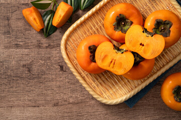 Fresh ripe persimmon fruit on wooden table background.