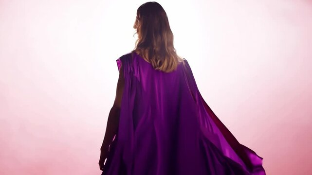 A woman, clad in a purple cape against a gradient pink background. She embodies the essence of feminism, equality, and activism. Feminist ideals, power, and solidarity. Generative AI