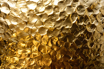 Hammered gold background with irregular hand hammered patterns and reflective glow