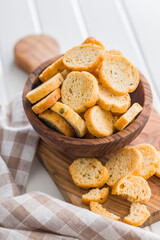 Sliced roasted bruschetta bread in bowl on white table.