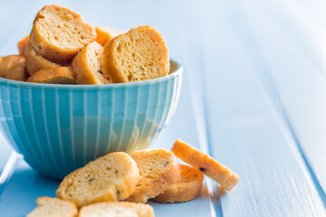 Sliced roasted bruschetta bread on blue table.