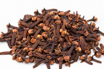 Obraz premium Cloves garlic and spices on white. spice food ingredient concept. handful of cloves of garlic on white with a green and brown . a handful of cloves of cinnamon and spices on a white with and a green.