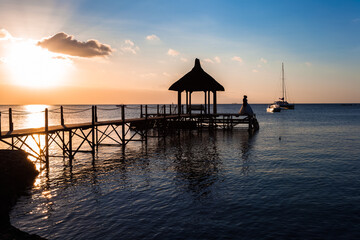 Couple sur ponton au coucher du soleil, île Maurice 