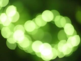 Fototapeta premium Soft green bokeh background with defocused lights creating a dreamy atmosphere, nature inspired, outdoor setting