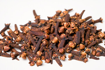 Fototapeta premium Cloves garlic and spices on white. spice food ingredient concept. handful of cloves of garlic on white with a green and brown . a handful of cloves of cinnamon and spices on a white and with a green.