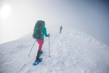 climbers climb the mountain. Winter mountaineering. two girls in snowshoes walk through the snow.