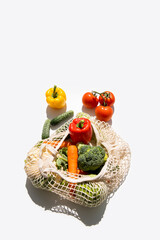 Fresh vegetables in a bag on a white background. Top view, flat lay