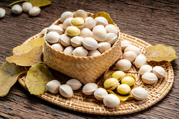 Fresh Ginkgo in wooden bowl on wooden background, Ginkgo seeds in wooden basket on wooden table.