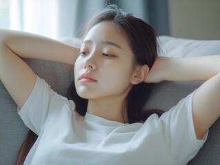 Naklejka premium Contemplative Moment: Woman Resting Her Head On Couch