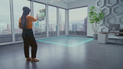 Talented Asian female designer in augmented reality headset uses virtual interior design software...