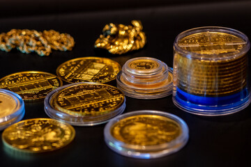 close-up real austrian philharmonic golden coins and gold objects in a black table. investments, savings, finances stock photo. Macro