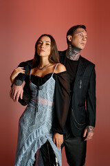 A striking couple poses together, blending contemporary style with eye catching tattoos.