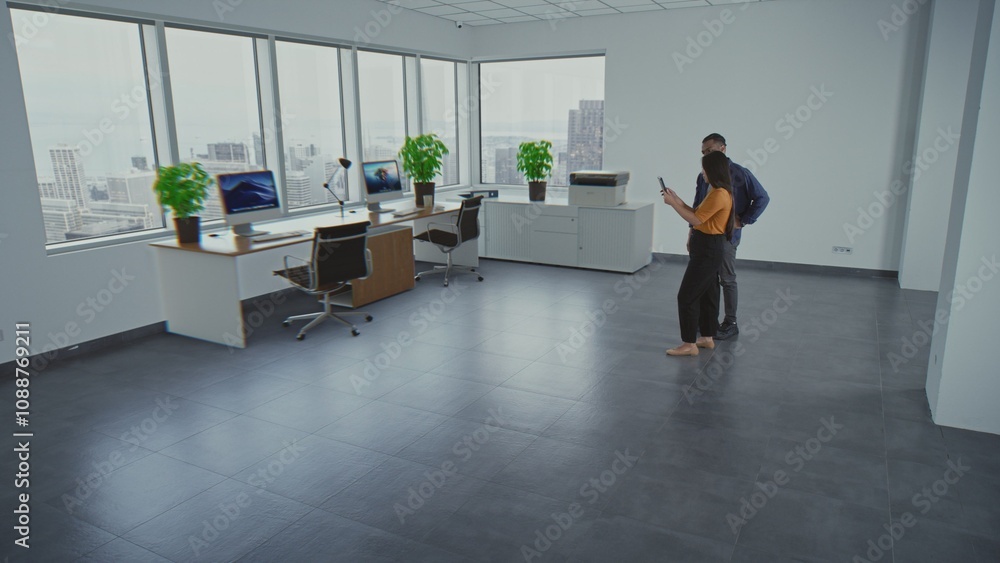 Poster multiethnic team of two designers using app on tablet computer to design interior in office room wit