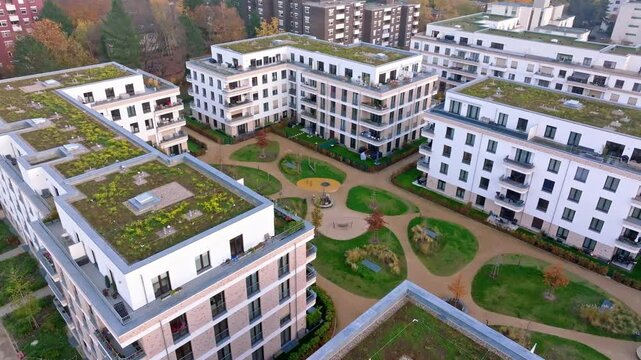Drone video of modern residential buildings with green roofs and a lush courtyard in Berlin Reinickendorf. The scene highlights sustainable urban living and eco-friendly architecture. Drone move right