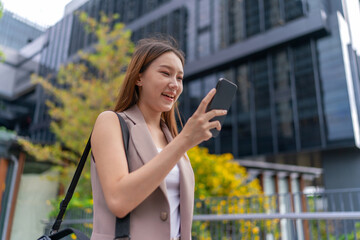 Asian Businesswoman Using Phone Amid Modern Office Building Background