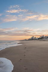 huellas de pies en atardecer, amanecer en la playa
