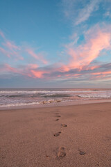 huellas de pies en atardecer, amanecer en la playa