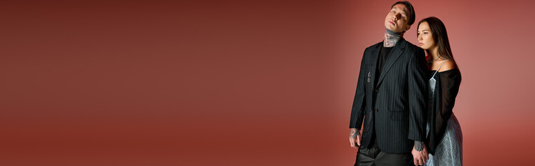 A stylish young couple poses together, highlighting their unique looks in a trendy setting.