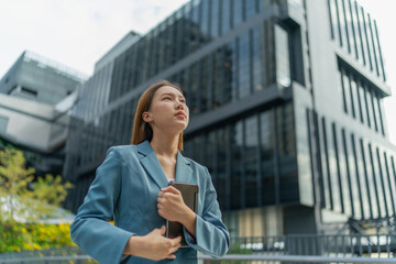 Young Businesswoman Using Digital Tablet In Front A Modern Office Building in a Financial District