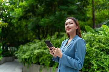 Asian Businesswoman Using Digital Tablet Amid Greenery in A Park