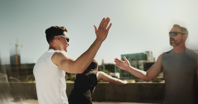 Outdoor, men and celebration with high five for fitness, marathon challenge and support on bridge. City, personal trainer and client with hand gesture for exercise, solidarity and target for workout
