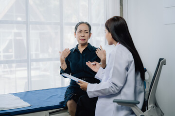 Doctor Patient Consultation: A compassionate doctor listens intently to an elderly patient,...