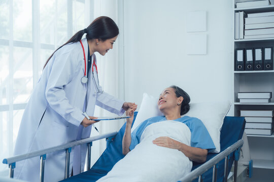 Compassionate Care: Doctor and Patient. A reassuring moment between a female doctor and her elderly patient in a hospital room.  The image conveys empathy, trust, and healing.