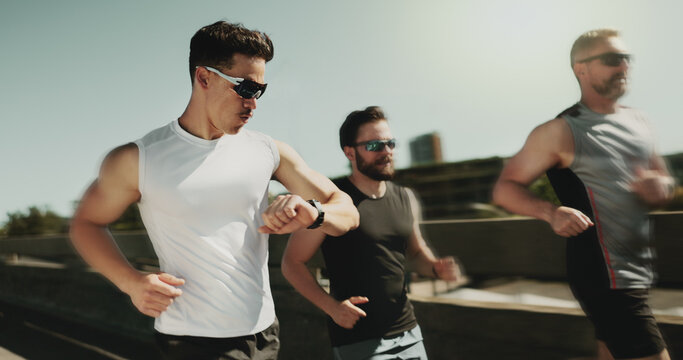 People, speed and running in city with watch, fitness tracker and check heart rate in urban town. Men, friends support and team blur for movement on street, outdoor cardio and monitor stats or timer - Powered by Adobe