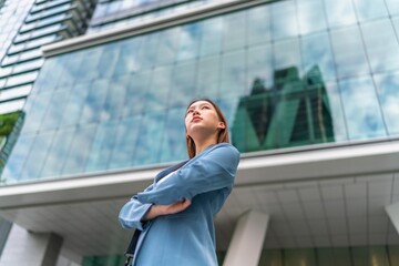 Confident Young Businesswoman With Laptop Bag In Front a Modern Office Building in a Financial...