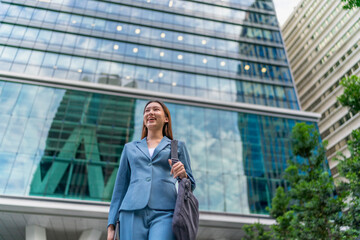 Fototapeta premium Portrait of a young and confident businesswoman standing in front a modern office building in the financial district
