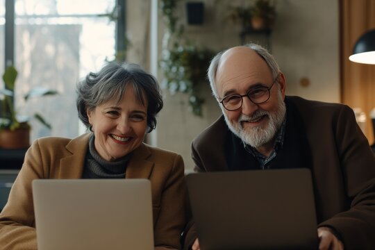 Middle aged professionals engaged in joyful video conference from home office setup with laptop