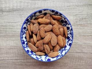 Natural roasted brown almonds in a decorative plate