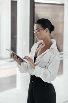 Businesswoman using a tablet computer analyzing stock exchange market crypto trading decreasing chart data fall down loss, desperate about losing money of crisis, recession, inflation. Economic crisis