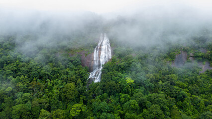 Aerial view of beautiful waterfall village in the lush green rain cloud and foggy cover tropical...