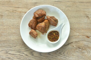 fried crispy slice fat pork in fish sauce on plate dipping with chili sauce
